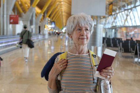 Foto de Primer plano retrato de mujer madura con pasaporte en el aeropuerto - Imagen libre de derechos