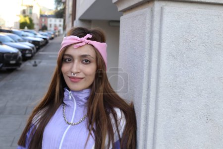 Téléchargez les photos : Portrait de femme hipster élégant portant bandeau et perçage sur fond urbain - en image libre de droit