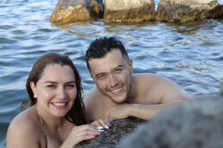 Photo for Close-up portrait of young couple posing together in water at rocky seashore - Royalty Free Image