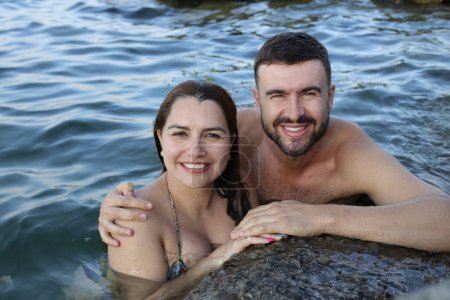 Téléchargez les photos : Portrait en gros plan de jeunes couples posant ensemble dans l'eau au bord de la mer rocheuse - en image libre de droit