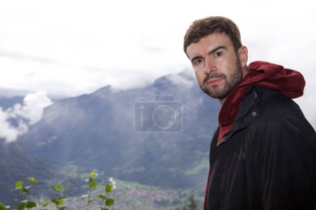 Téléchargez les photos : Portrait d'un beau jeune homme heureux voyageant dans les montagnes - en image libre de droit