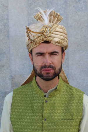 Téléchargez les photos : Portrait de beau jeune homme indien avec turban dans la rue - en image libre de droit