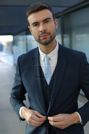 Téléchargez les photos : Portrait de beau jeune homme d'affaires en costume dans la rue de la ville - en image libre de droit