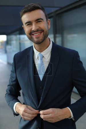 Téléchargez les photos : Portrait de beau jeune homme d'affaires en costume dans la rue de la ville - en image libre de droit