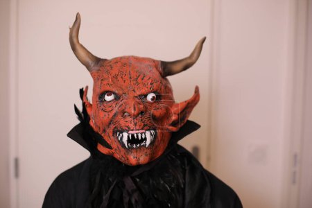 Téléchargez les photos : Portrait en gros plan de la personne dans le masque du diable intérieur - en image libre de droit