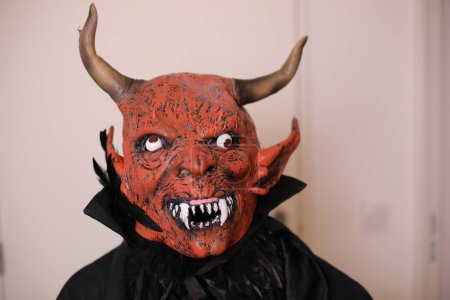Téléchargez les photos : Portrait en gros plan de la personne dans le masque du diable intérieur - en image libre de droit