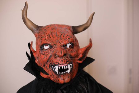 Foto de Primer plano retrato de persona en diablo máscara interior - Imagen libre de derechos