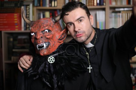 Photo for Close-up portrait of handsome young priest with demon indoor - Royalty Free Image