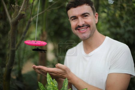 Photo for Portrait of handsome young man feeding butterfly in tropical forest - Royalty Free Image
