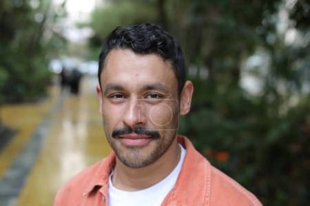 Téléchargez les photos : Portrait d'homme hispanique souriant heureux avec moustache sur la rue de la ville regardant la caméra - en image libre de droit