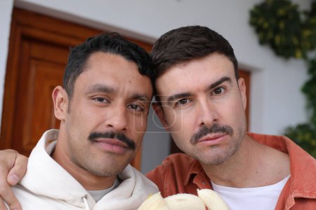 Photo for Young happy gay couple of two handsome men with bananas - Royalty Free Image