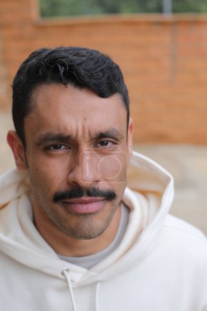 Photo for Portrait of handsome hispanic man with mustache in white hoodie looking at camera - Royalty Free Image