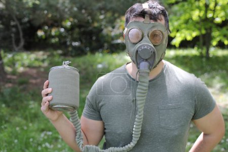 Photo for Man wearing vintage gas mask in natural setting - Royalty Free Image