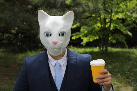 Téléchargez les photos : Homme d'affaires avec un visage de chat sur fond de nature - en image libre de droit