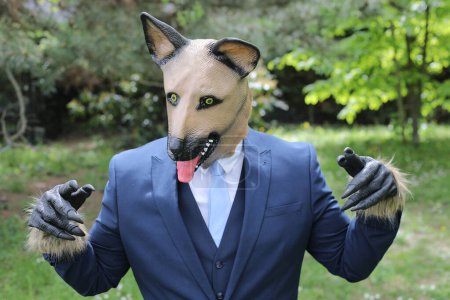 Téléchargez les photos : Homme d'affaires avec un visage de chien sur fond de nature - en image libre de droit
