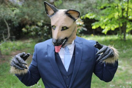 Téléchargez les photos : Homme d'affaires avec un visage de chien sur fond de nature - en image libre de droit