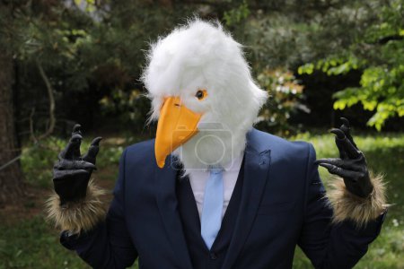 Téléchargez les photos : Homme d'affaires avec un visage d'aigle sur fond de nature - en image libre de droit