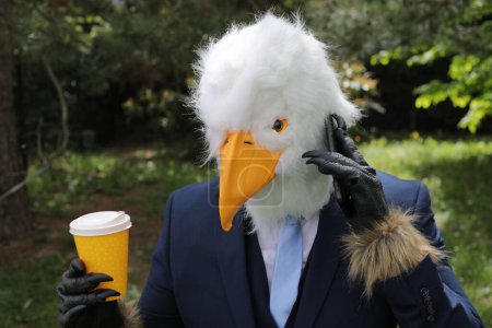 Businessman with an eagle face making a phone call
