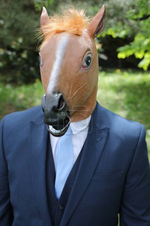 Foto de Empresario con cara de caballo sobre fondo natural - Imagen libre de derechos