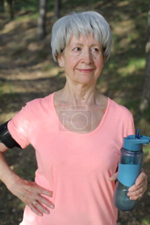 Foto de Senior mujer activa sosteniendo botella de agua - Imagen libre de derechos