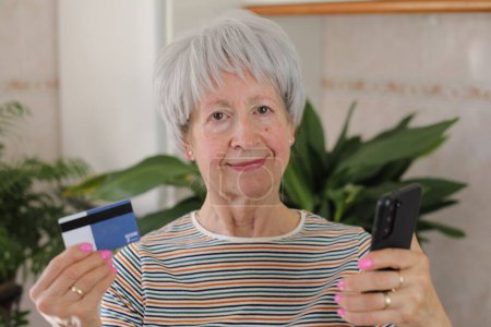 Foto de Mujer mayor usando su tarjeta de crédito para comprar en línea - Imagen libre de derechos