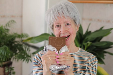 Seniorin genießt etwas Schokolade