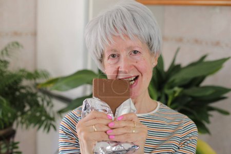 Photo for Senior woman enjoying some chocolate - Royalty Free Image