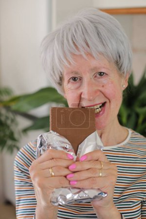 Photo for Senior woman enjoying some chocolate - Royalty Free Image
