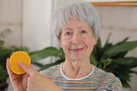 Femme âgée montrant l'intérieur d'un fruit