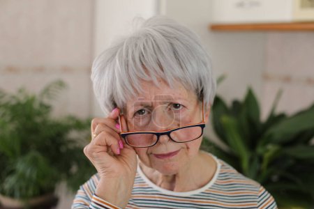 Photo for Senior woman squinting and putting her eyeglasses down - Royalty Free Image