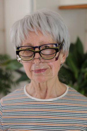 Photo for Senior woman wearing three eyeglasses simultaneously - Royalty Free Image
