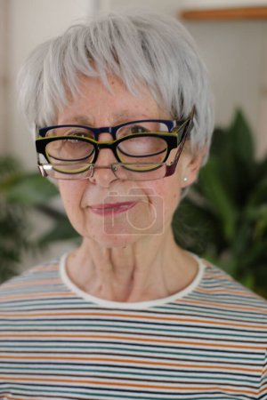 Senior woman wearing three eyeglasses simultaneously