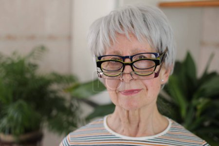 Téléchargez les photos : Femme âgée portant trois lunettes simultanément - en image libre de droit