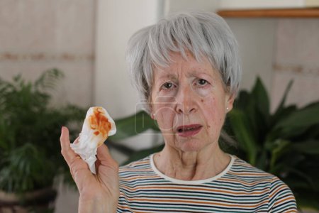 Foto de Mujer mayor tosiendo saliva con sangre - Imagen libre de derechos