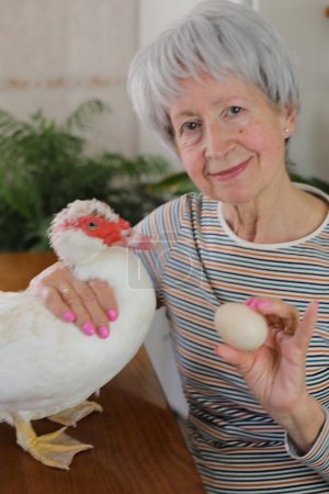 Téléchargez les photos : Femme âgée montrant un délicieux oeuf de canard - en image libre de droit