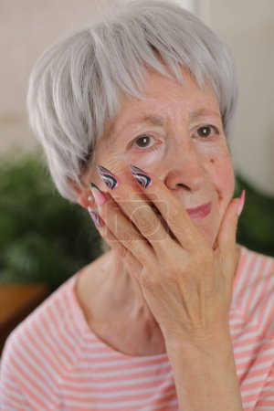 Foto de Mujer mayor con uñas largas multicolores artísticas - Imagen libre de derechos