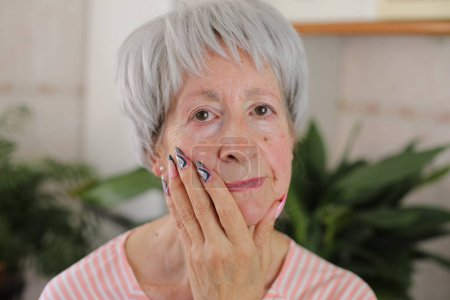 Foto de Mujer mayor con uñas largas multicolores artísticas - Imagen libre de derechos