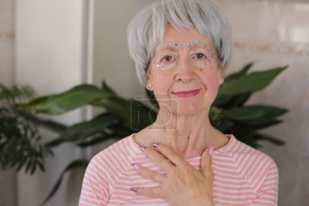 Photo for Senior woman wearing extravagant gemstones on face make up - Royalty Free Image
