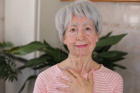 Foto de Mujer mayor con piedras preciosas extravagantes en la cara conforman - Imagen libre de derechos