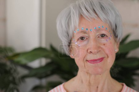 Foto de Mujer mayor con piedras preciosas extravagantes en la cara conforman - Imagen libre de derechos