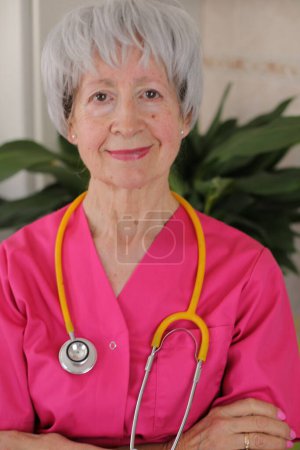 Téléchargez les photos : Infirmière principale portant des blouses roses et un stéthoscope jaune - en image libre de droit
