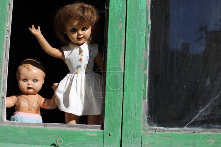 Téléchargez les photos : Poupées effrayantes dans une maison abandonnée en arrière-plan, gros plan - en image libre de droit