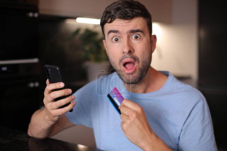 Homme utilisant sa carte de crédit pour faire des achats en ligne