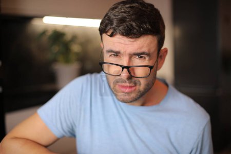 Téléchargez les photos : Homme plissant et mettant ses lunettes vers le bas - en image libre de droit