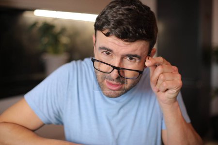 Photo for Man squinting and putting his eyeglasses down - Royalty Free Image