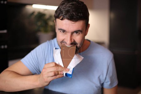 Hombre hambriento disfrutando un poco de chocolate