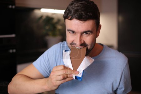 Foto de Hombre hambriento disfrutando un poco de chocolate - Imagen libre de derechos