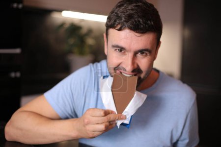 Hungriger Mann genießt etwas Schokolade