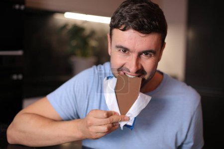 Foto de Hombre hambriento disfrutando un poco de chocolate - Imagen libre de derechos