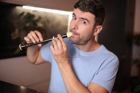 Photo for Adult man playing the flute on background, close up - Royalty Free Image